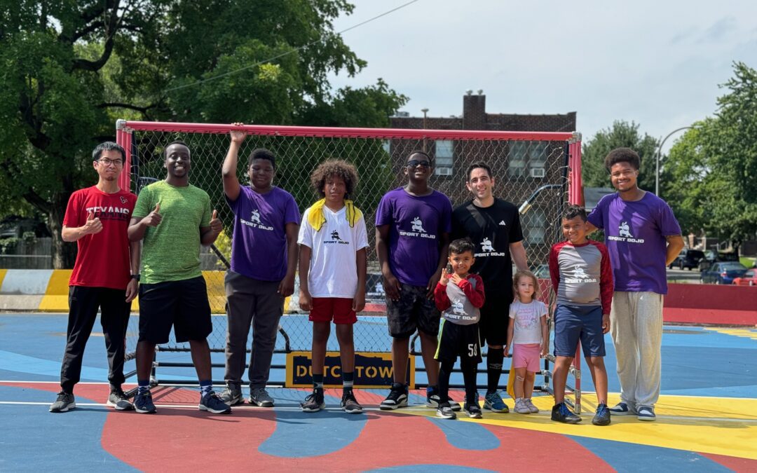 A group of boys at Sport Dojo summer camp smile with their camp counselor on the sport court