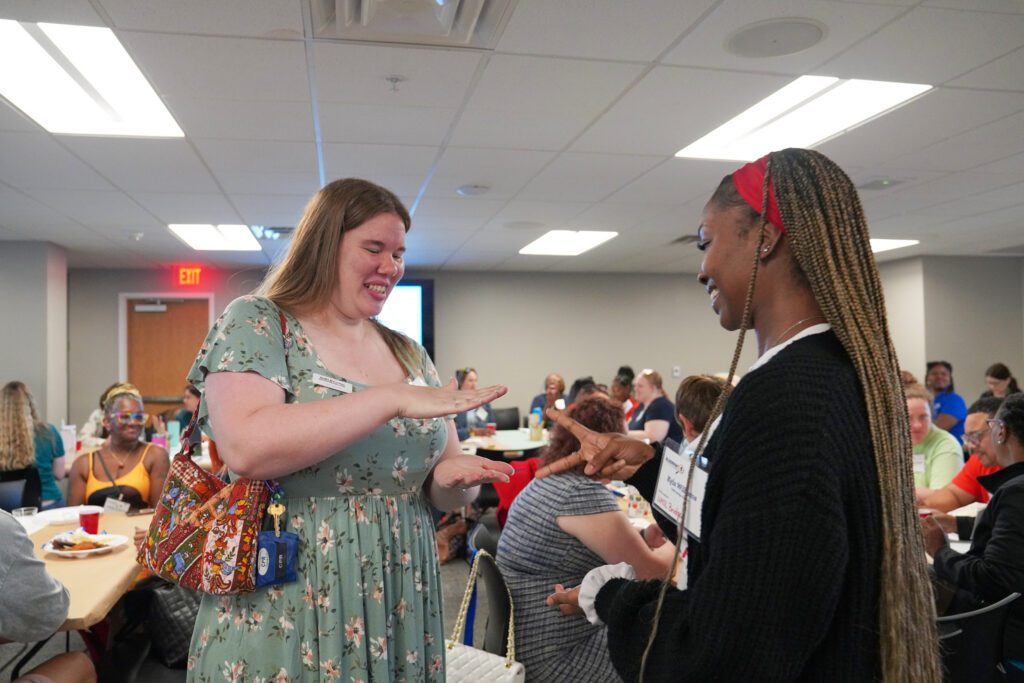 Two camp providers play rock paper scissors.