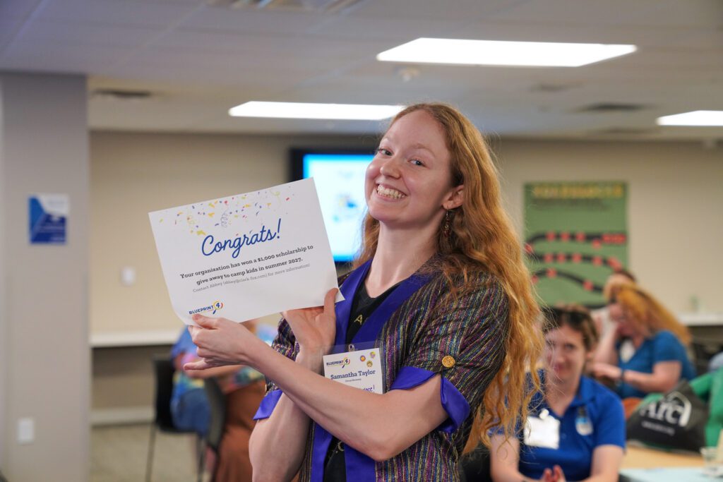 Samantha Taylor from Circus Harmony holds up a certificate that says "Congrats!"