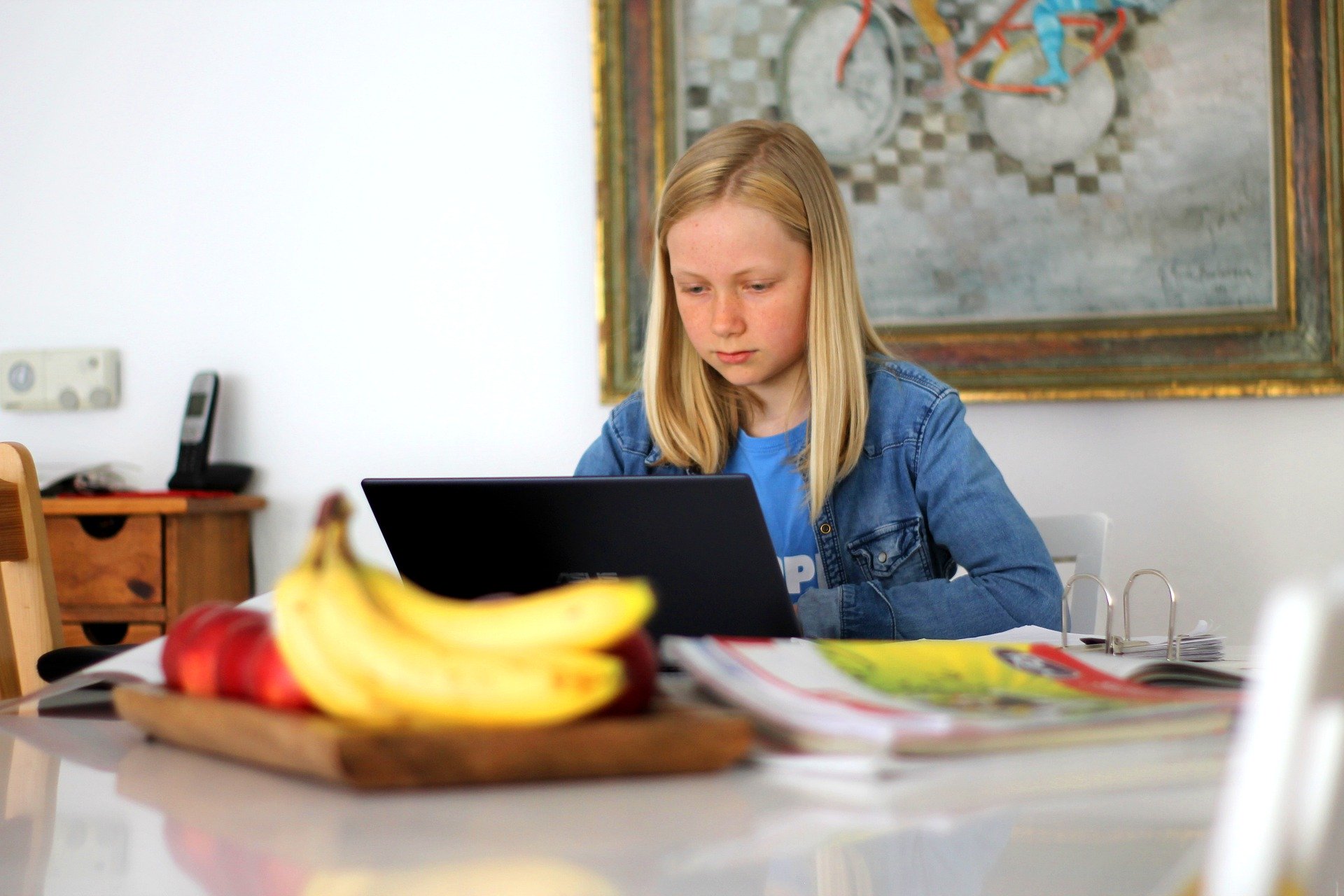 Virtual Summer Camp - Girl at table with laptop and bananas